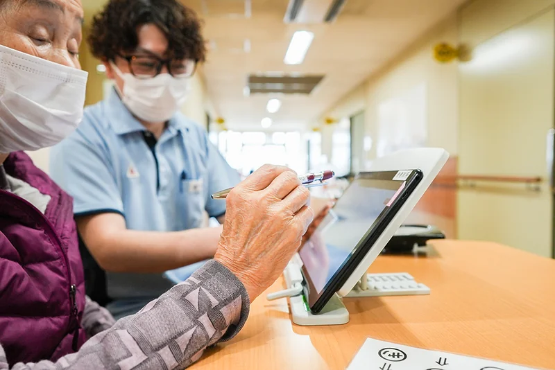 職員と利用者がタブレットを使って活動する様子