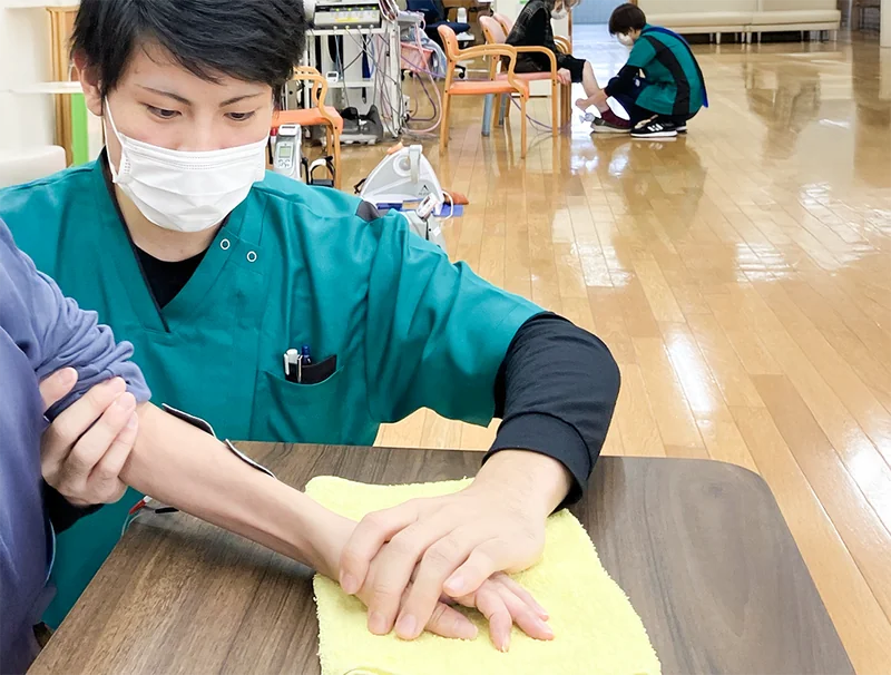 職員が利用者の手の動きを支援する様子