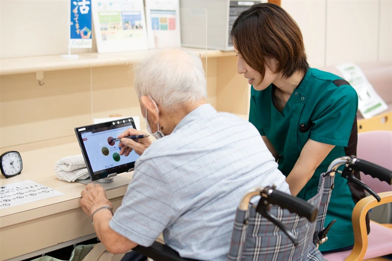 タブレットを使った個別練習に取り組む利用者と職員