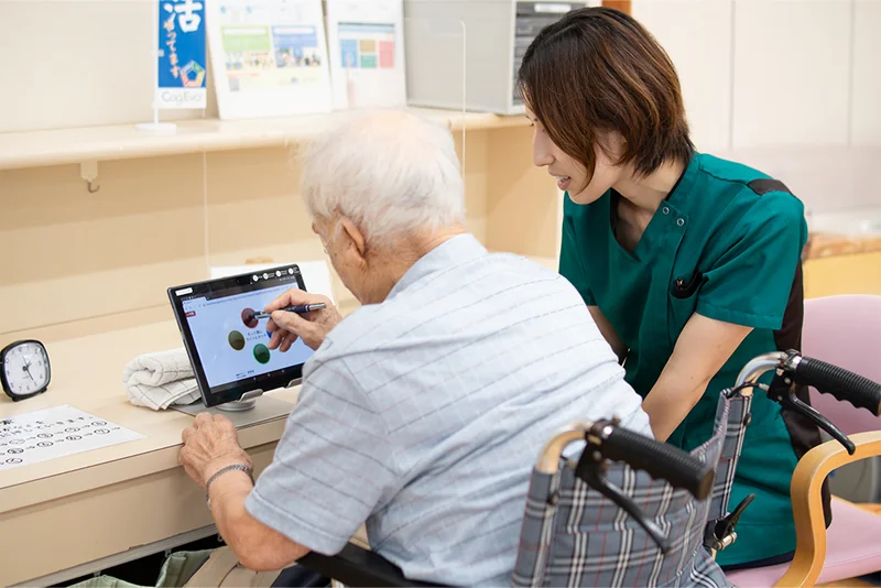 タブレットを使った生活支援に取り組む利用者と職員